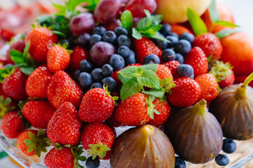 assorted fruits and berries on a plate. delicious and healthy vegetarian dessert