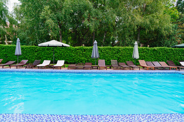 empty sun loungers in the pool. the concept of summer holidays.