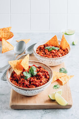 Chili con carne in a clay bowl on a concrete or stone rustic background- traditional dish of mexican cuisine.Top view.