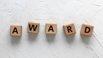 Text AWARD on wooden cubes on white background. Square wood blocks. Top view, flat lay.