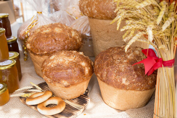 Fresh round bread with a golden crust close-up on a wooden board.