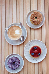 Cappuchino and desserts, tart and donut on the wooden table