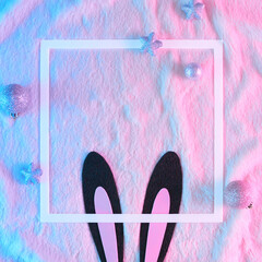 Creative flat lay Christmas background made with Black rabbit ears like symbol of new year 2023 in vibrant gradient holographic neon colors on fur background. Minimal New Year concept.