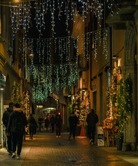 shopping in the historic center illuminated by Christmas decorations.Como - Italy