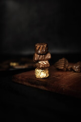 Chocolate bars on a wooden board and on a dark background. Dark style. Minimal food concept. Creative idea.