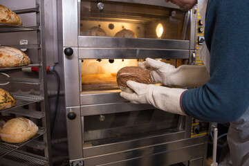 Baker carrying a tray of freshly baked bread