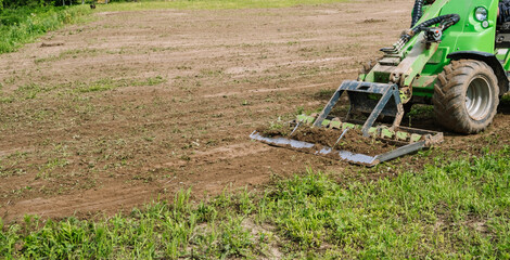 Land work by the territory improvement. Small tractor with a ground leveler for moving soil, turf....