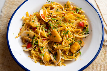 Noodles with monkfish and red peppers. Traditional tapa cooked in paella. Spanish original recipe.