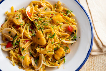 Noodles with monkfish and red peppers. Traditional tapa cooked in paella. Spanish original recipe.