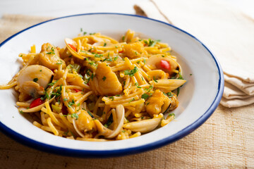 Noodles with monkfish and red peppers. Traditional tapa cooked in paella. Spanish original recipe.