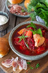 National dish of Ukrainian cuisine borscht with vegetables, turkey meat, herbs, sour cream and traditional bread (bun with garlic and dill, pampushka) with bacon (pork). Cultural heritage.