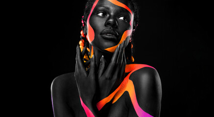 The Art Face. Black and yellow body paint on african woman. Abstract creative portrait. Bright fashion makeup on the girl.