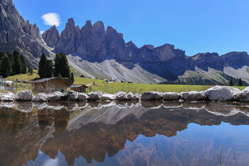 Reflection of Alpine peaks of Odle Group at Geisler Alm, Dolomites Italy, Val Di Funes