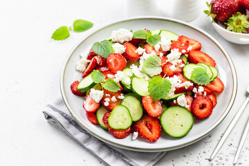 Vegan healthy strawberry cucumber water melon  feta cheese salad on plate. Top view, flat lay, copy space.