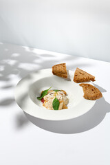 Beef tartar with mushroom espuma and foie gras on fine dining. Aesthetic composition with foie gras appetizer. Fine dining on summer. Delicatessen food on white table. © Ryzhkov
