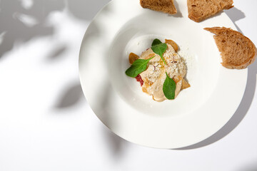 Beef tartar with mushroom espuma and foie gras on fine dining. Aesthetic composition with foie gras appetizer. Fine dining on summer. Delicatessen food on white table.