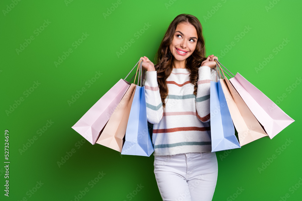 Poster Photo of dreamy shiny girl dressed striped pullover rising shoppers looking empty space isolated green color background