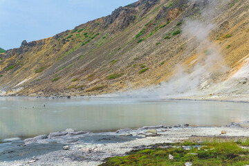hot mineralized lake with thermal spring and smoking fumaroles in the caldera of the Golovnin volcano on the island of Kunashir