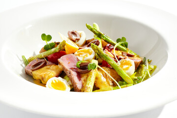Classic Nicoise salad with grilled tuna, potatoes, asparagus, tomatoes and olives with mustard...
