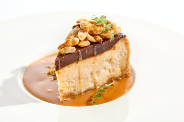 Nuts tart isolated on white background. Sweet pie with nuts and caramel sauce. Dessert with praline, chocolate and cashew, hazelnut, peanut and caramel sauce. Toffee nut pie in restaurant menu.