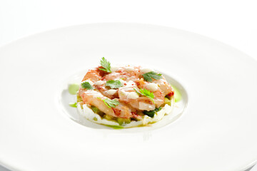 Restaurant dish - shrimp tartare with avocado, cream cheese, sweet chilli sauce on white plate. Ceviche with marinated prawn, avocado and spicy vegetables. Prawn tartare isolated on white background