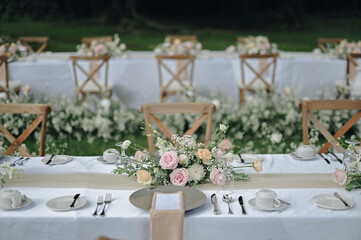 ideas for Wedding Decoration outdoors with white pink and orange flowers in the day light. Table Setting outdoors with flowers arrangement. Refreshing nature environment 