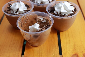 Elegant and delightful tasting chocolate mousse cups in wooden background