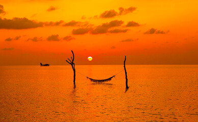 Sunset on Maldives island. Beautiful sky and ocean and beach with palms background for summer...