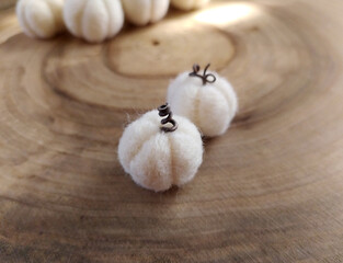 Handmade pumpkins white felt on a wood background. Wool pumpkins. Concept: Halloween decor. Selective focus.