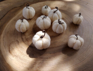 Handmade pumpkins white felt on a wood background. Wool pumpkins. Concept: Halloween decor. Selective focus.