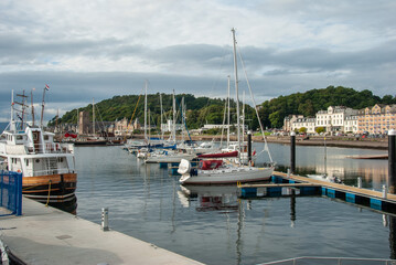 Fototapeta na wymiar Seafront view with docked boats in Oban resort town within the Argyll and Bute council area of Scotland, United Kingdom