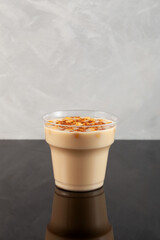 Boza or Bosa in disposable plastic take away cup. Turkish drink with roasted chickpea