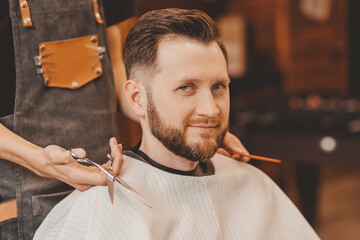 Happy Man in barber chair, hairdresser styling hair. Concept barbershop banner, vintage color
