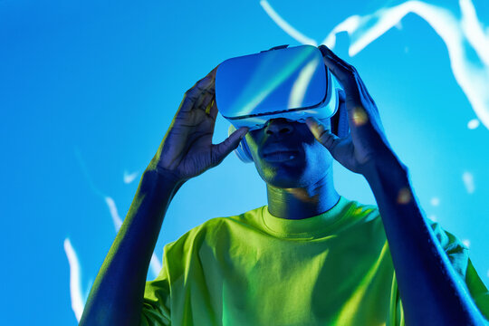 Young African American male watching video in VR goggles