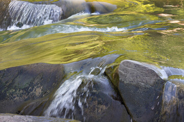 Rough current of a mountain river and stones. Beautiful movement of water in the wild. Freshness of...