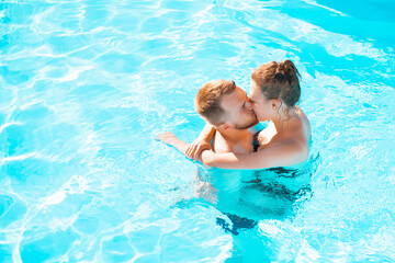 Romantic couple kissing in a blue swimming pool. Enjoying. Gentle. Passion. Paradise. Perfect....