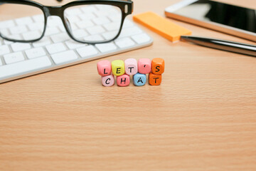 Colorful cubes with LET'S CHAT message on the wooden office table 