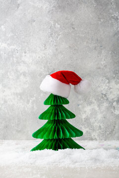 Green paper Christmas tree with red santa hat holiday decor