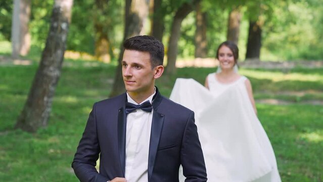 Newlyweds walk in the park. Bride Groom straddled like a horse. Slow motion