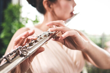 Asian woman blowing the flute, a universal classical instrument. The concept of a classical music school. music teacher