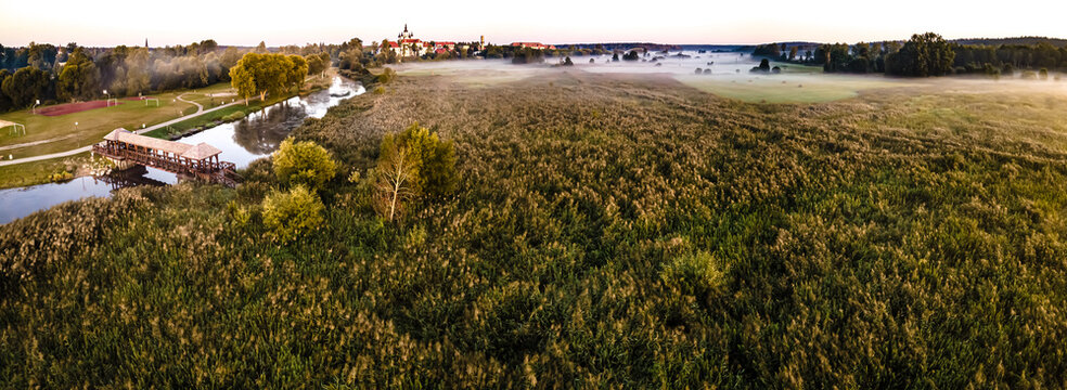 Panorama of the city of Suprasl at sunrise in the morning fog.
