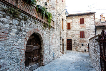 Fototapeta na wymiar Old wooden door in a medieval building in Gubbio, Umbria, Italy, Europe