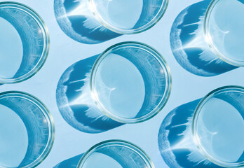petri dish with liquid water on plain blue background water texture	