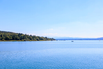 View over Ammersee lake in Bavaria with sailboats on the water and Ammergau Alps in the background