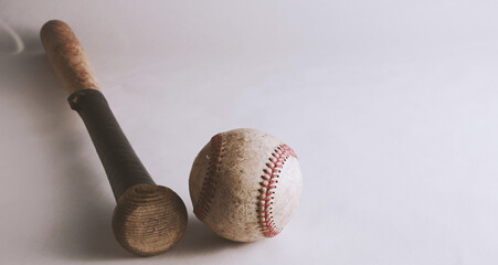 Rustic baseball sport background with old used ball by wooden bat.