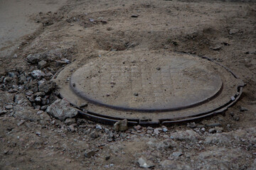 An old manhole hatch in a ruined city