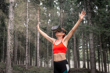 Sporty woman wearing virual reality headset exercising in a virtual forest.