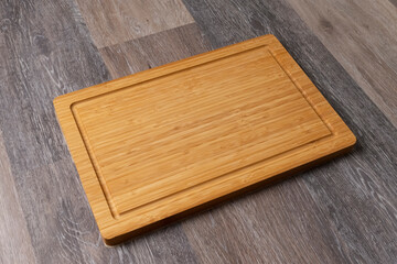 Empty cutting board on a wooden table, close-up, copy space for text.