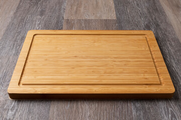 Empty cutting board on a wooden table, close-up, copy space for text.