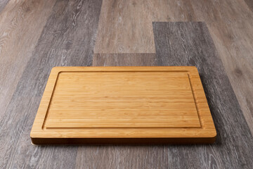 Empty cutting board on a wooden table, close-up, copy space for text.